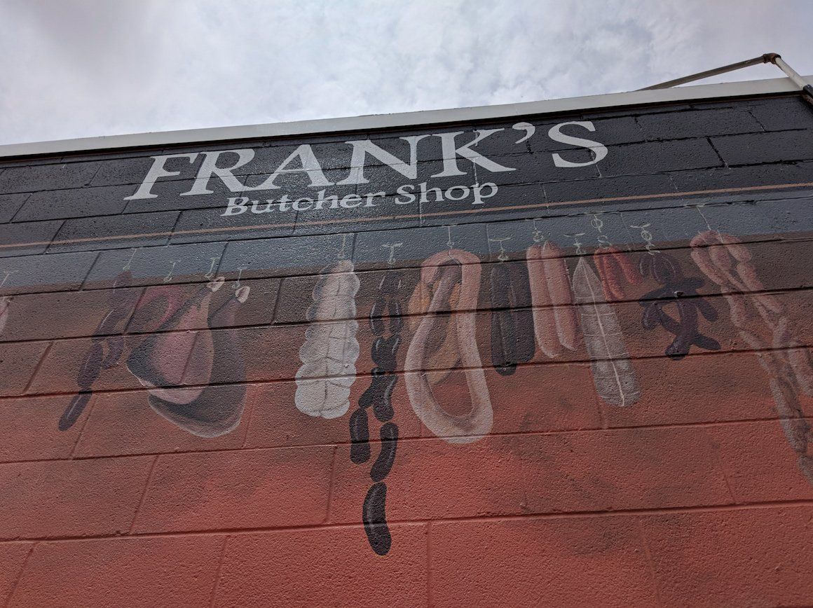 A brick building with a sign that says frank 's butcher shop