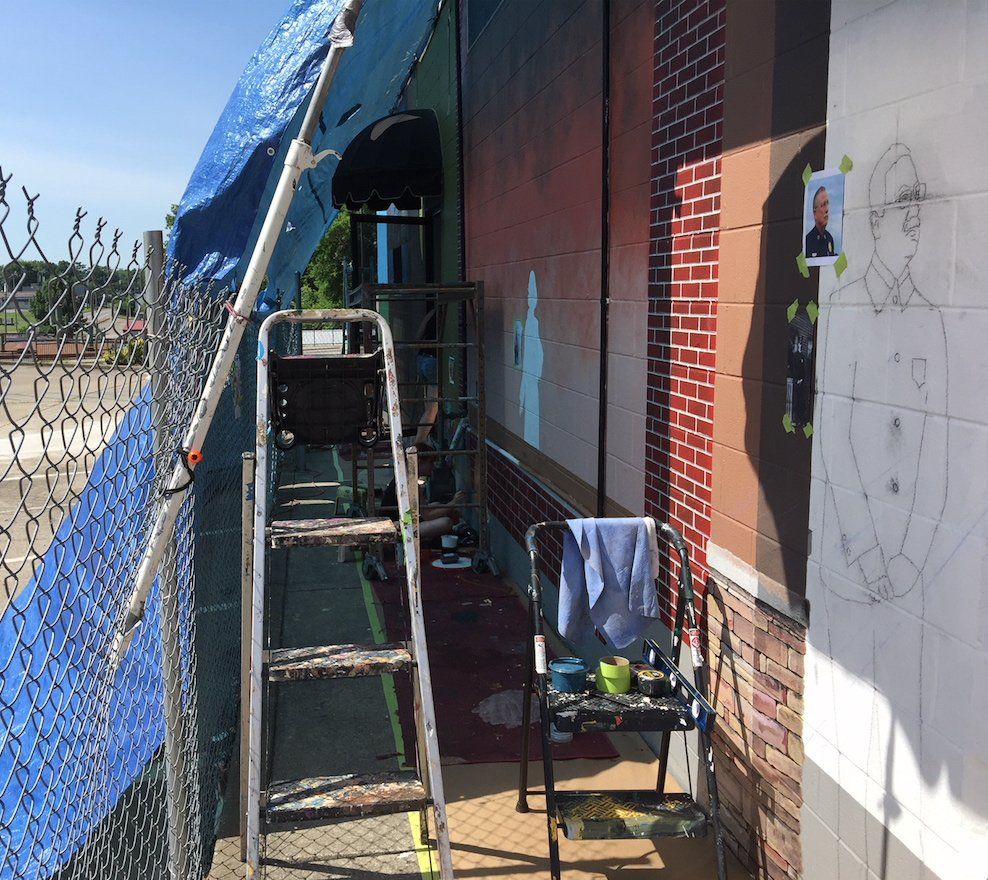 A ladder is sitting in front of a brick building