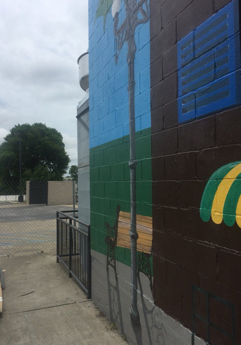 A brick building with a mural on the side of it.