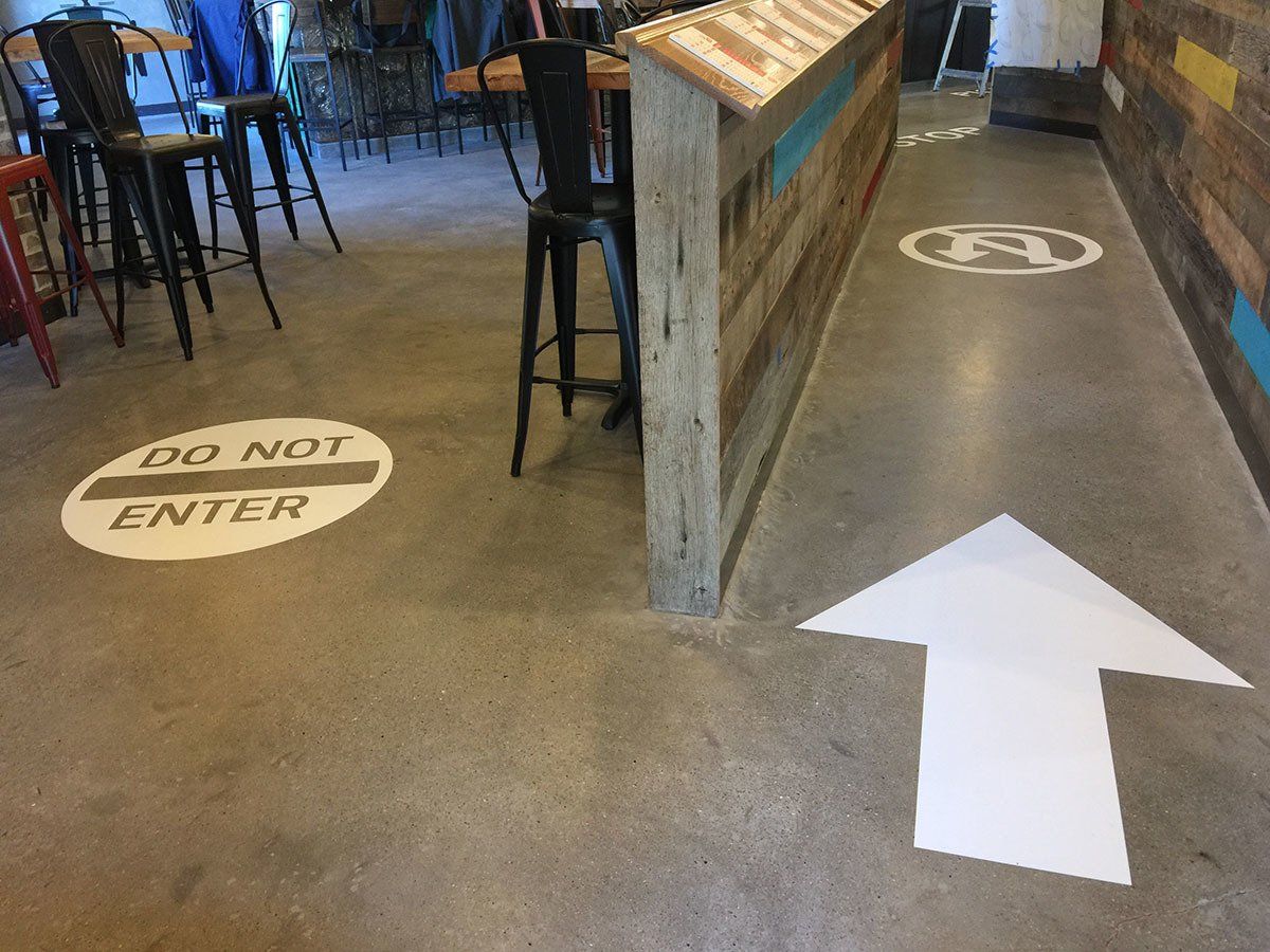 A do not enter sign is painted on the floor of a restaurant.