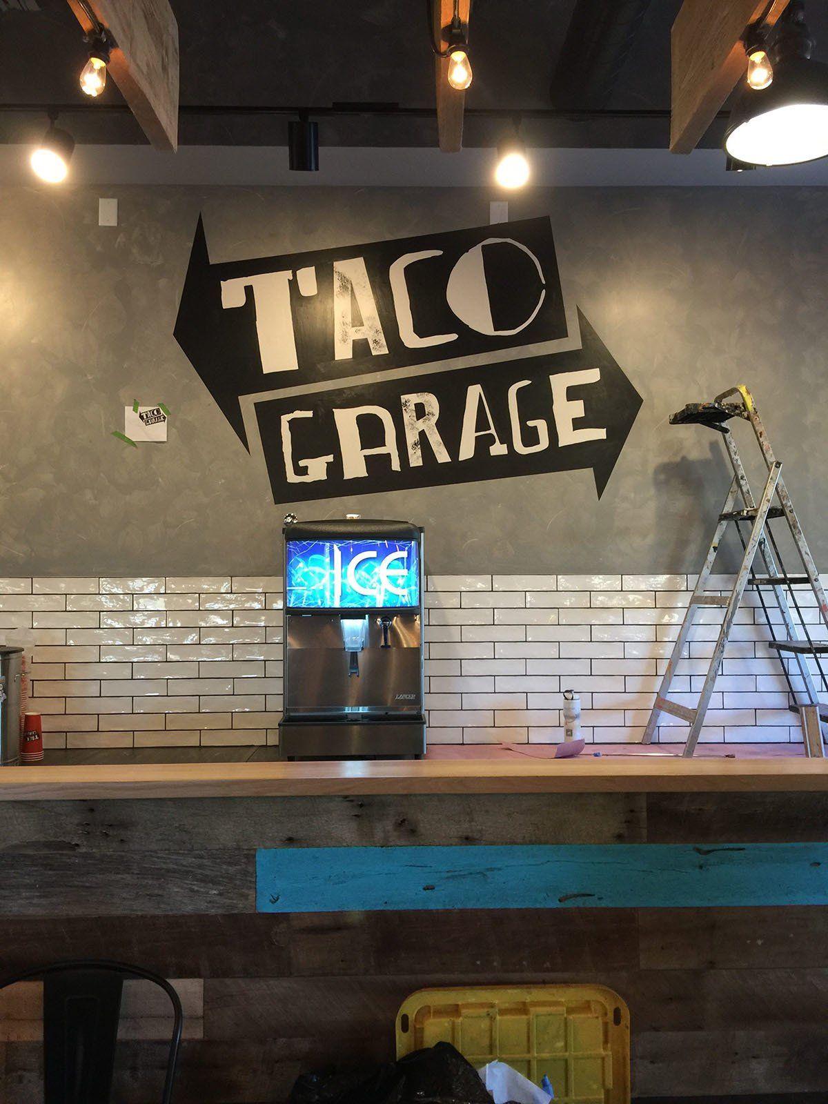 A taco garage sign is painted on the wall of a restaurant