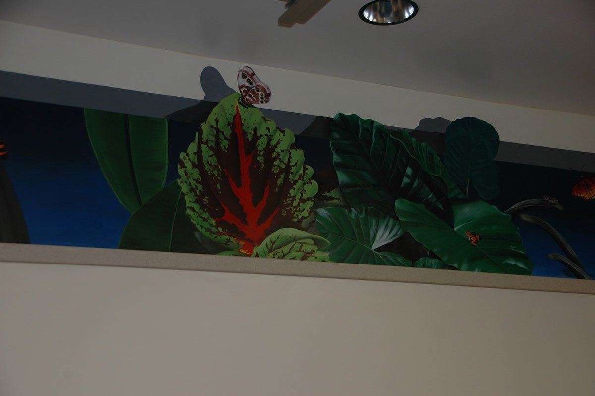 A wall with a painting of plants on it