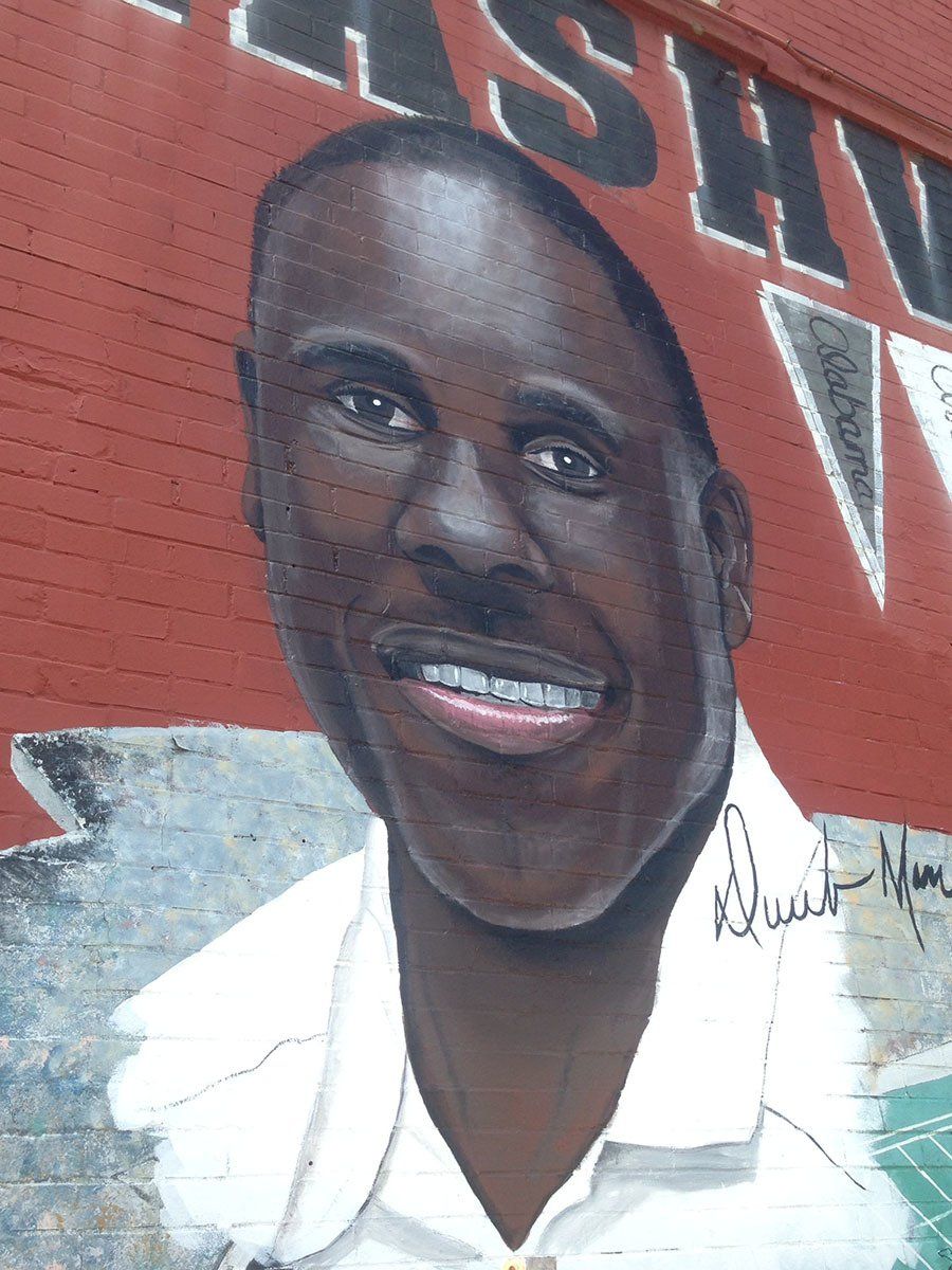 A painting of a man on a red wall with the word ash on it