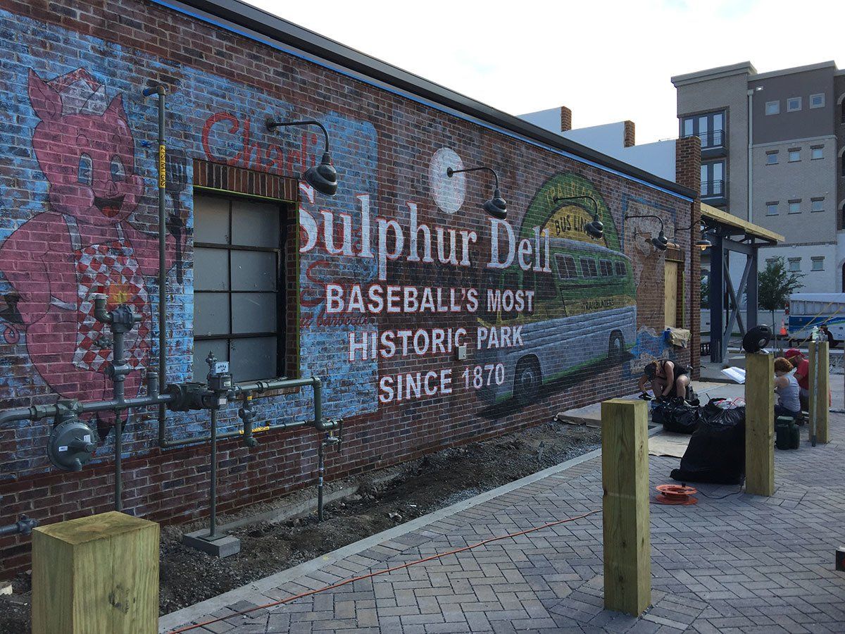 A large mural on the side of a brick building says sulphur dell baseball 's most historic park since 1910.