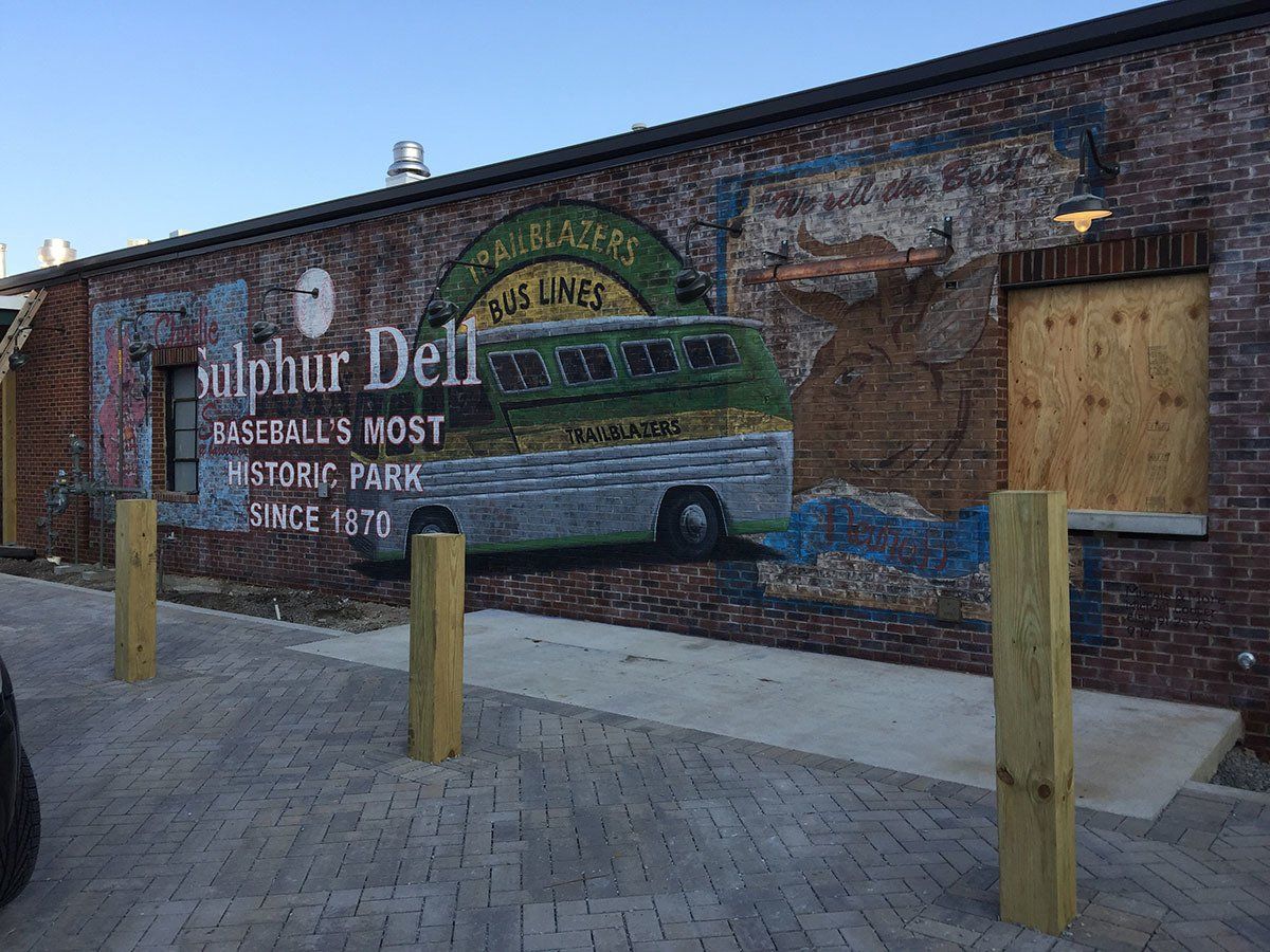 A brick building with a mural of a bus on the side of it.