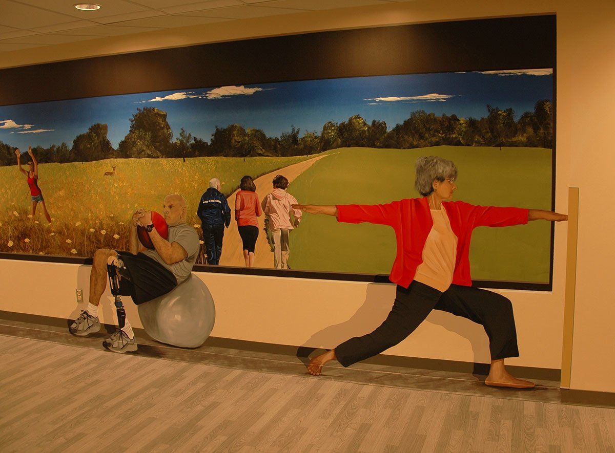 A woman in a red jacket is doing a yoga pose in front of a large painting