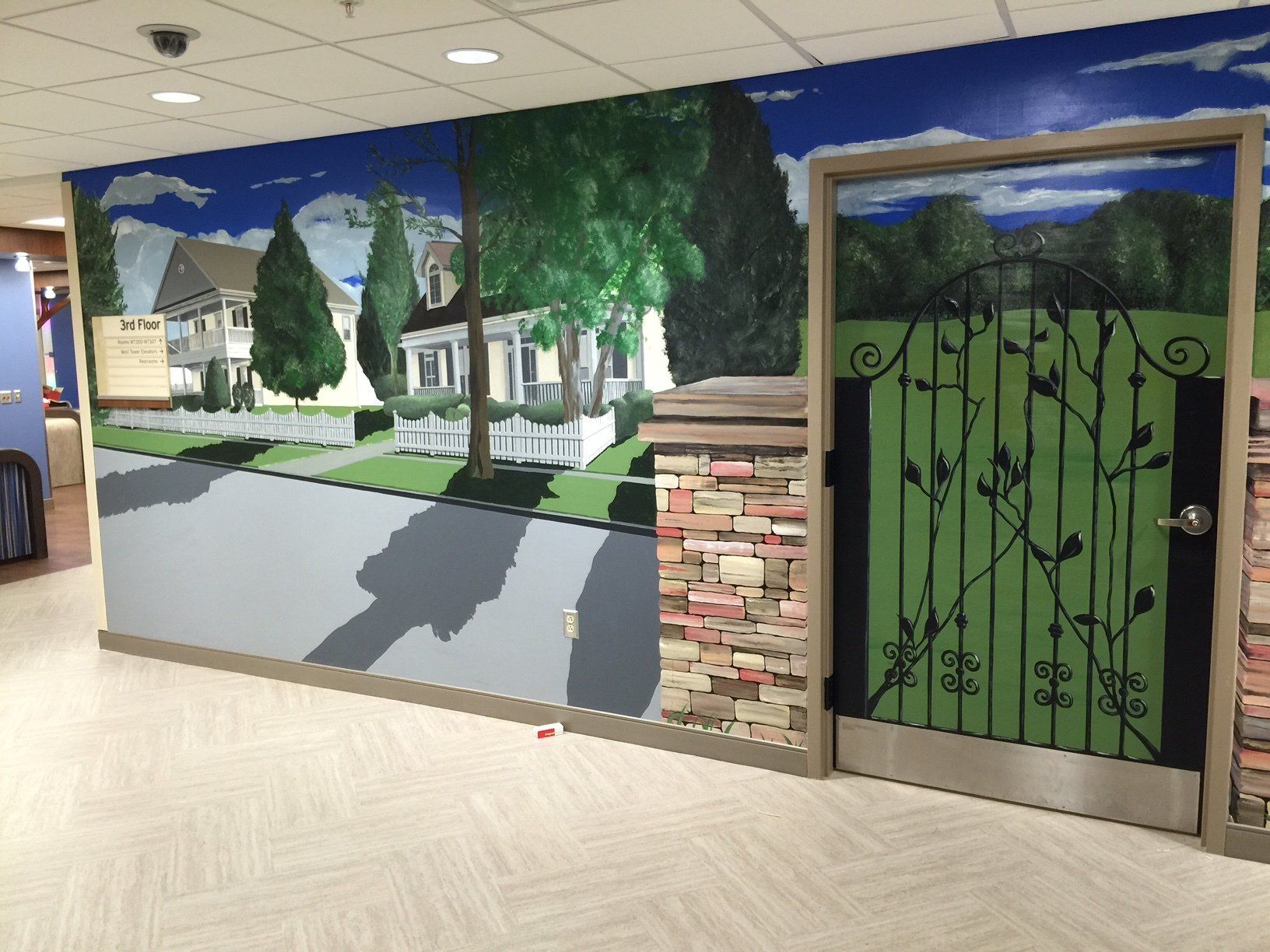 A hallway with a mural on the wall and a gate