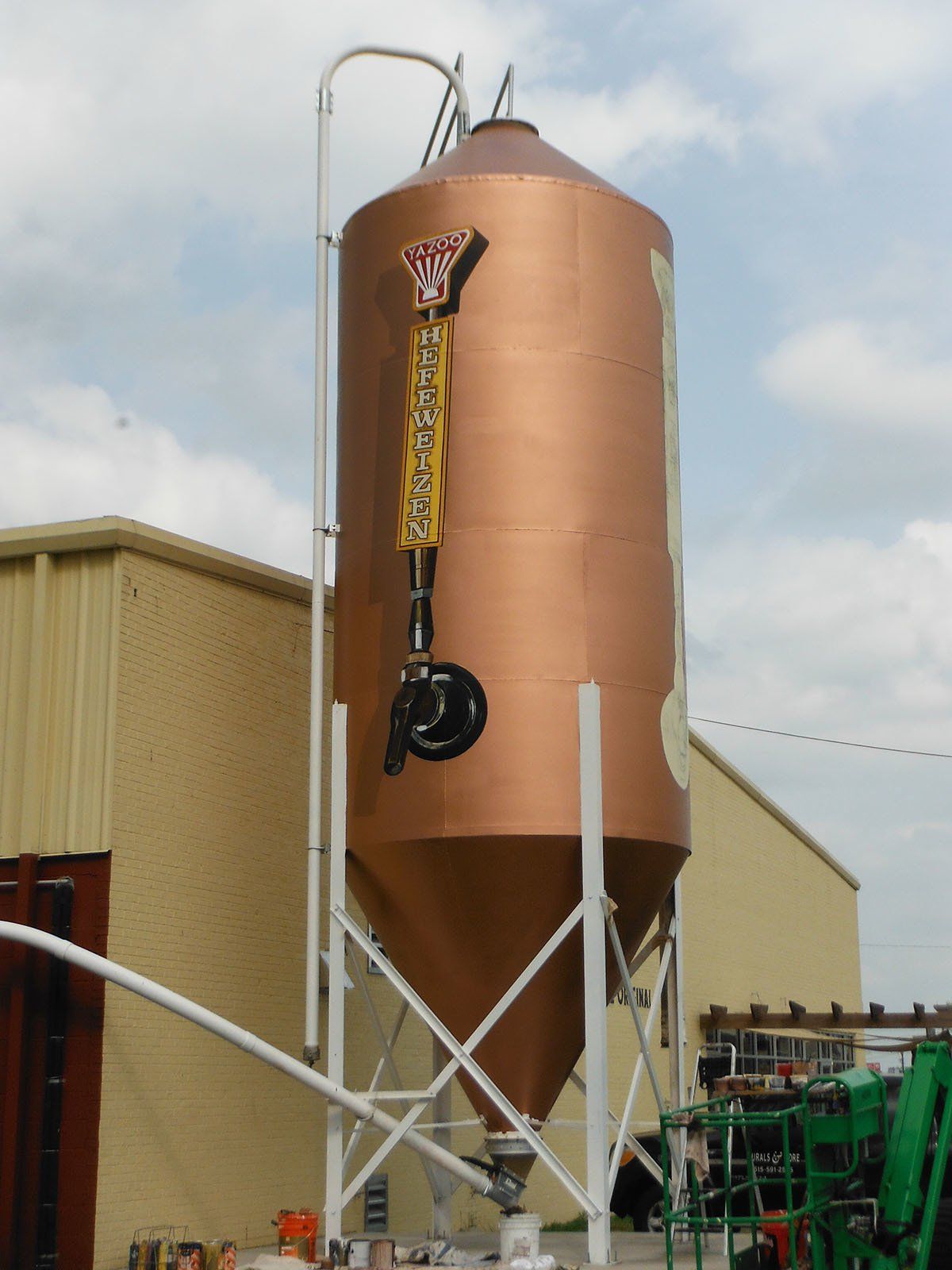 A large copper silo with a woody character on it