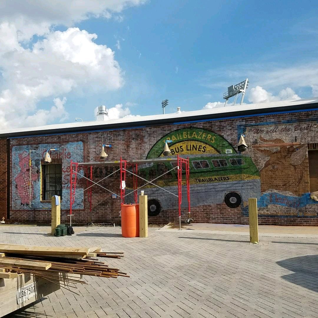 A brick building with a mural on the side of it.