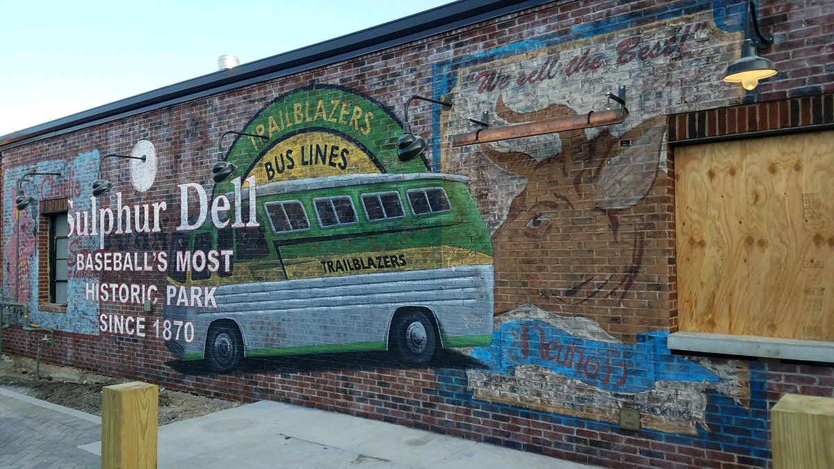 A brick building with a mural of a bus on it.