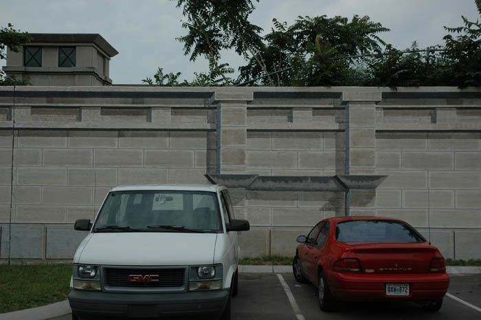 A white gmc van is parked next to a red car