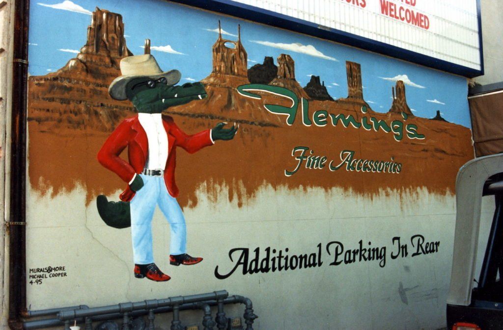A painting of a crocodile on the side of a building that says additional parking in rear