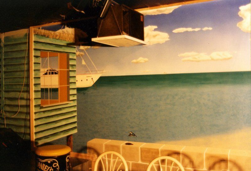 A room with a painting of a boat on the wall