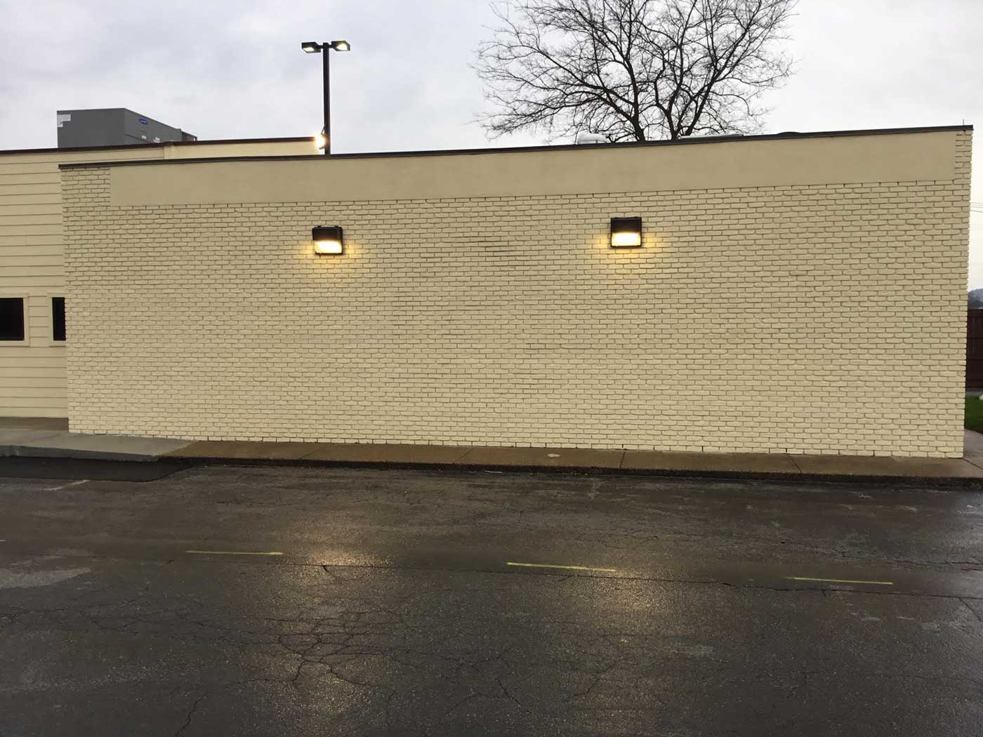 A white brick building with lights on the side of it