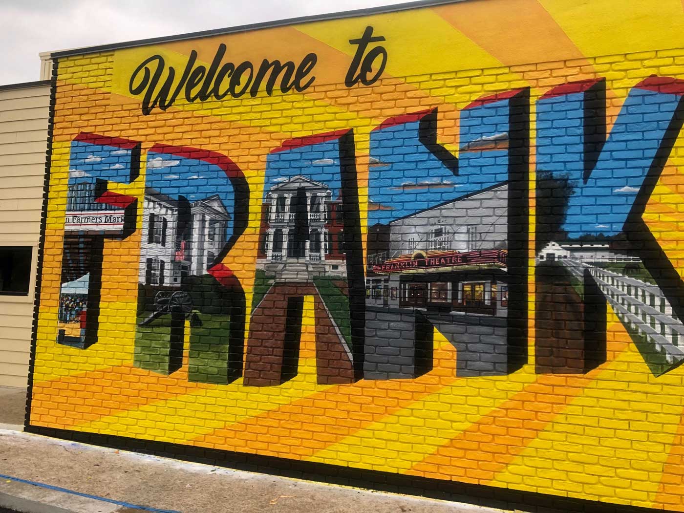 A mural on a brick wall that says welcome to frank