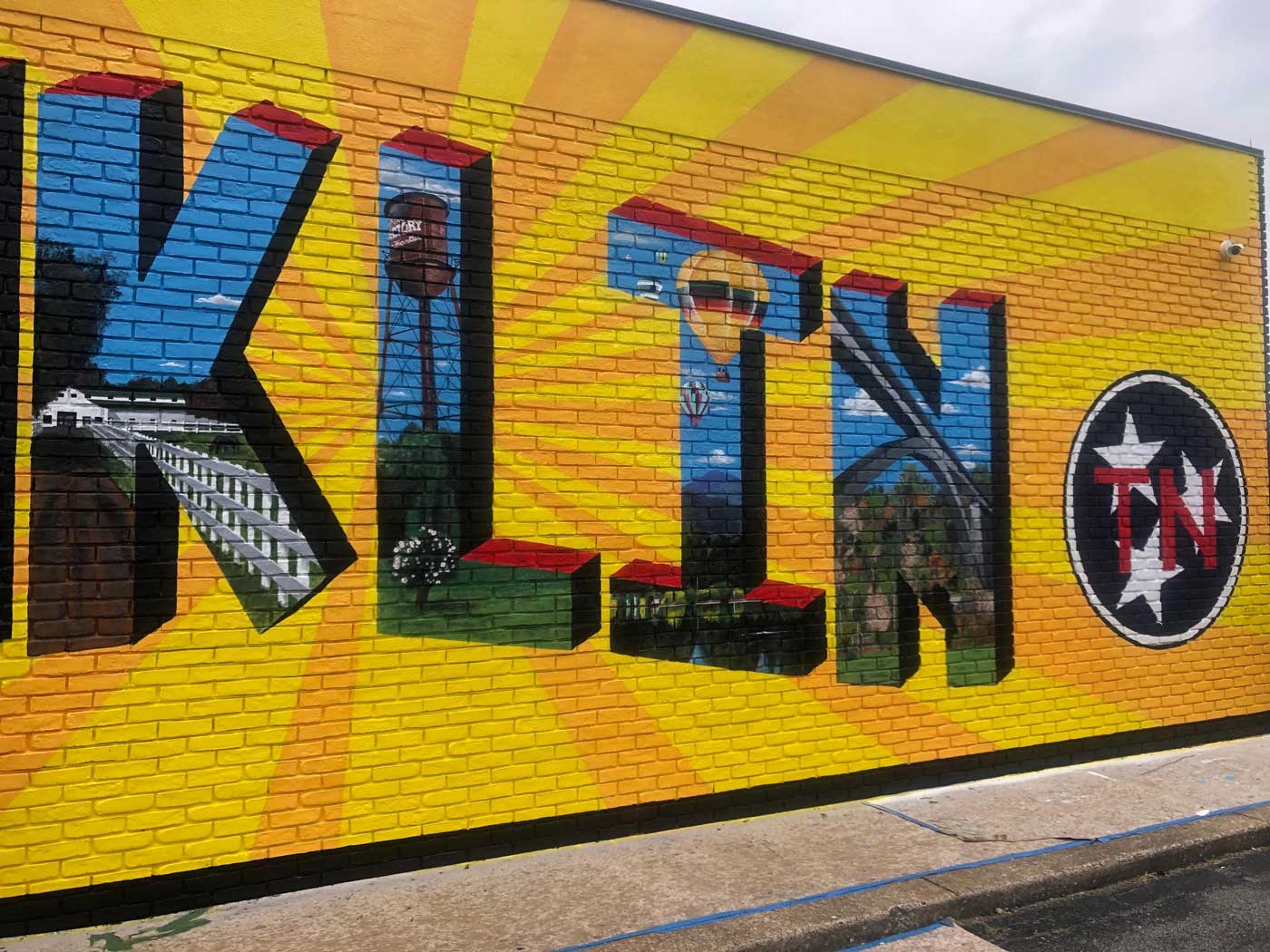 A colorful mural on a brick wall says klin