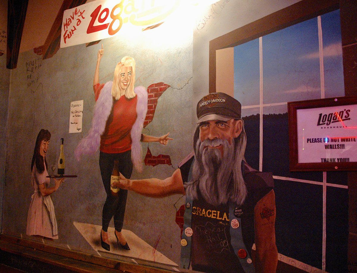 A man with a beard is standing in front of a sign that says log on it