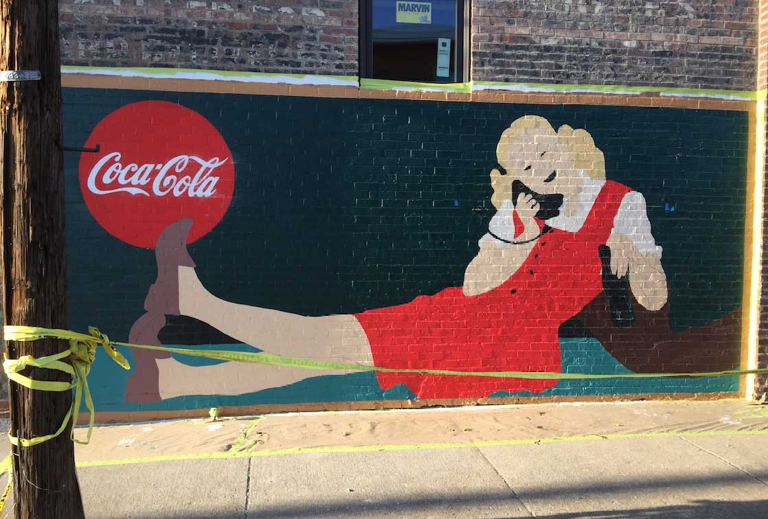 A coca cola advertisement on a brick wall