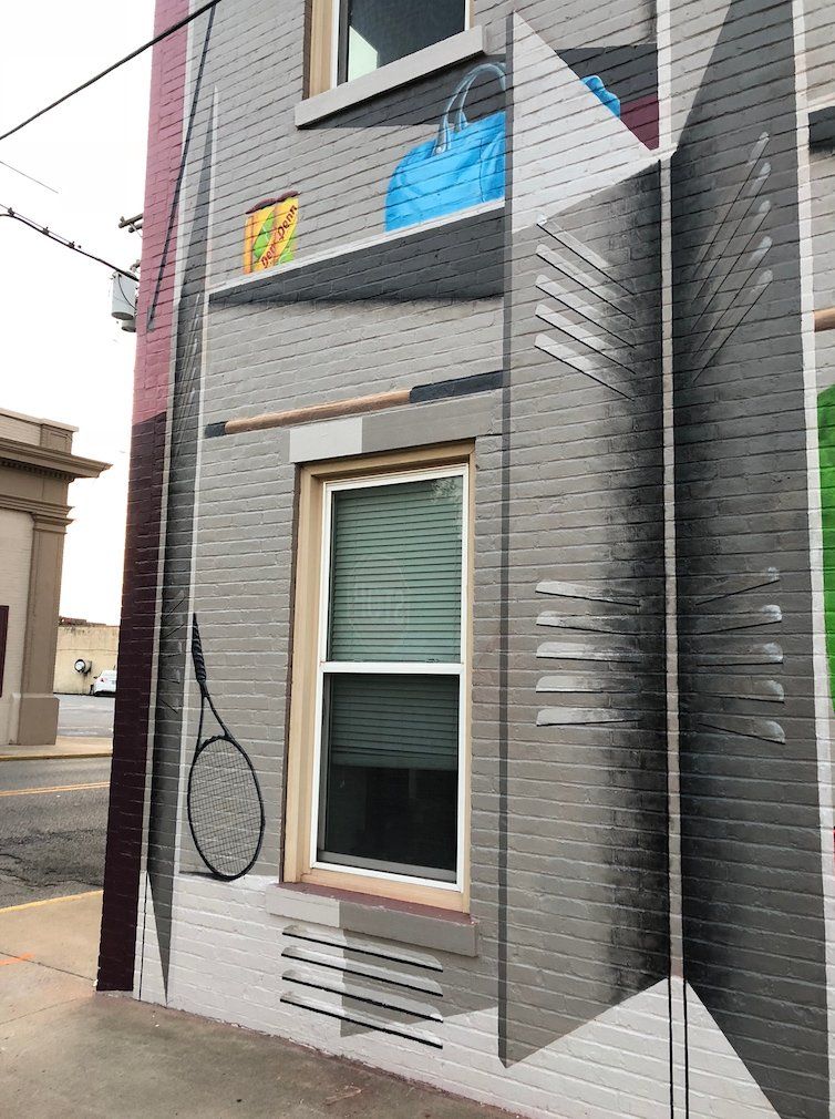 A mural on the side of a building with a window and a tennis racket.