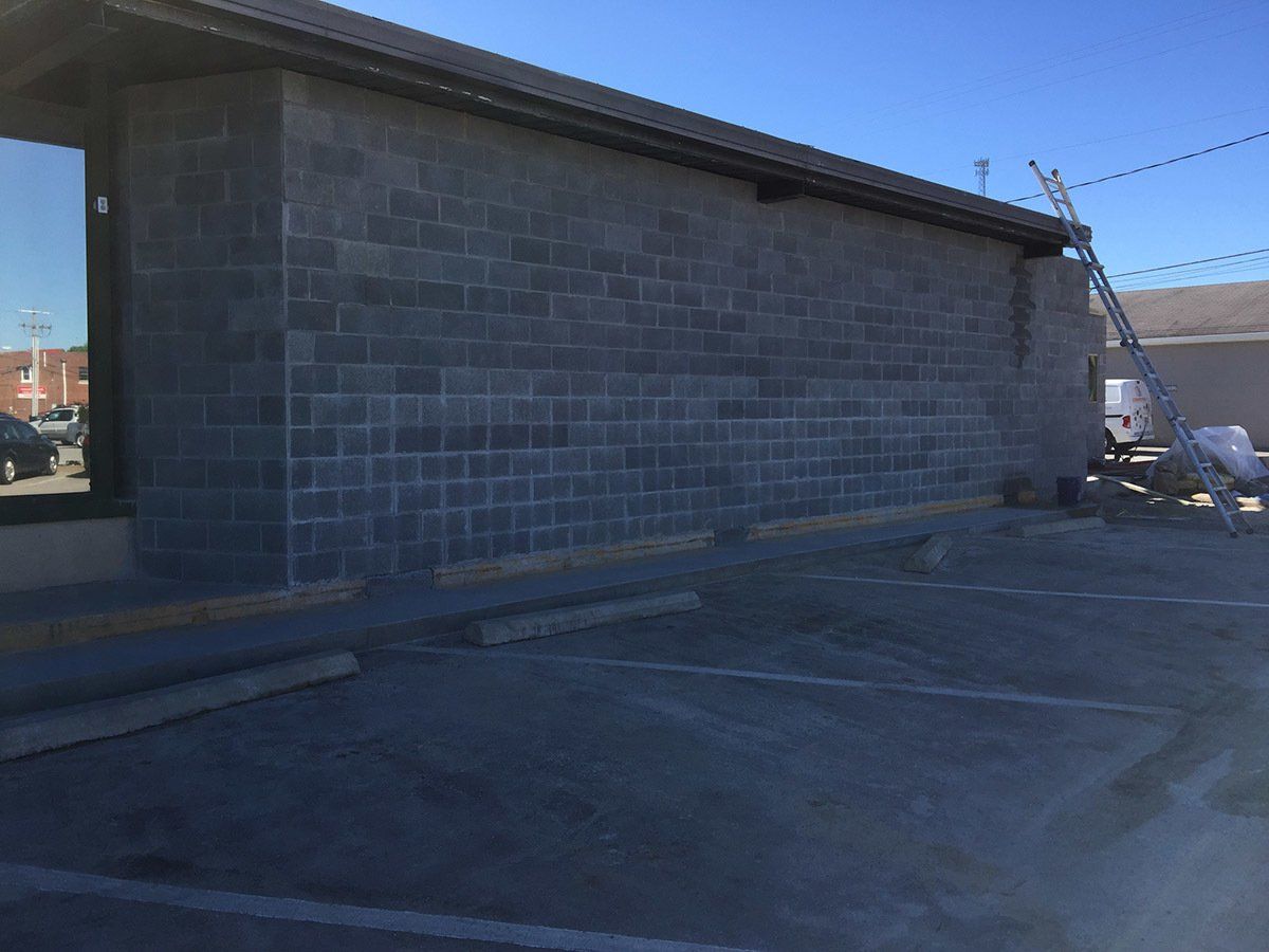 A brick building with a ladder in front of it