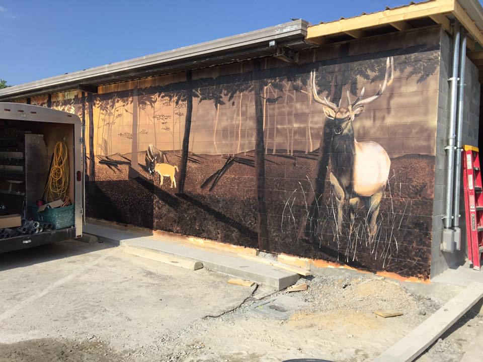 A large painting of a deer on the side of a building
