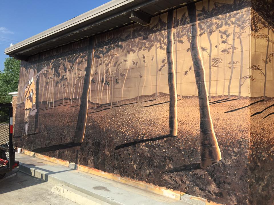 A large painting of trees on the side of a building
