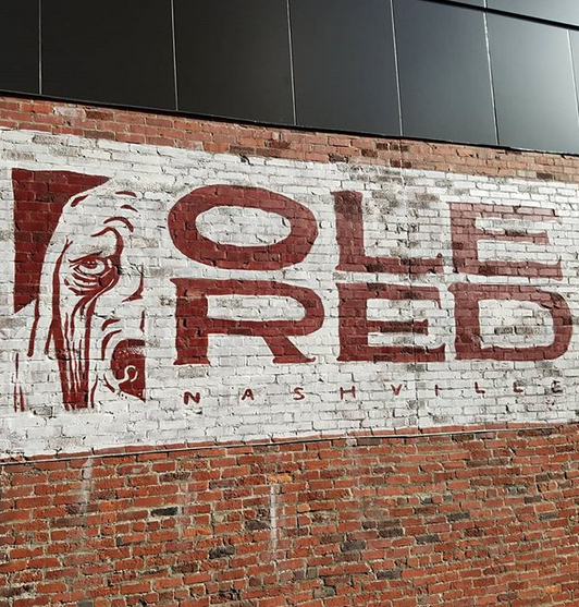 A brick wall with ole red painted on it