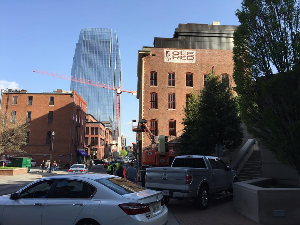 A white car is parked in front of a building that says 1826
