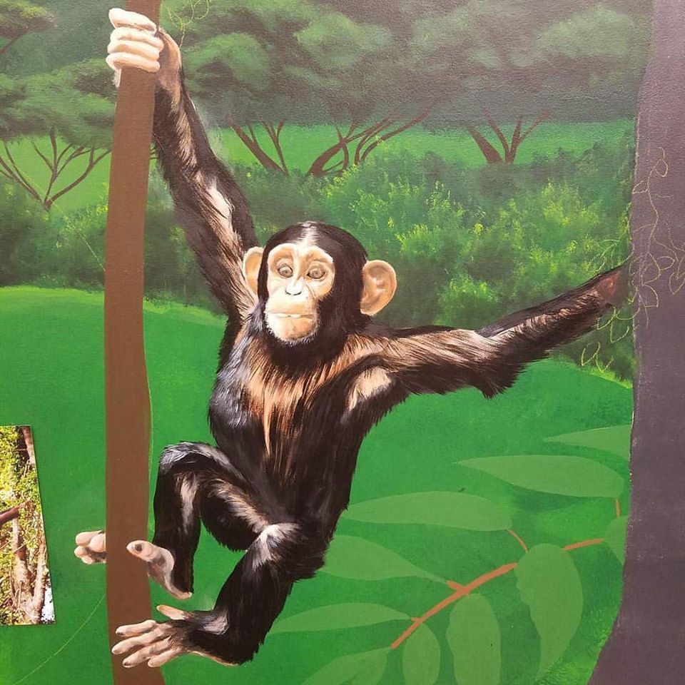 A painting of a chimpanzee hanging from a tree branch