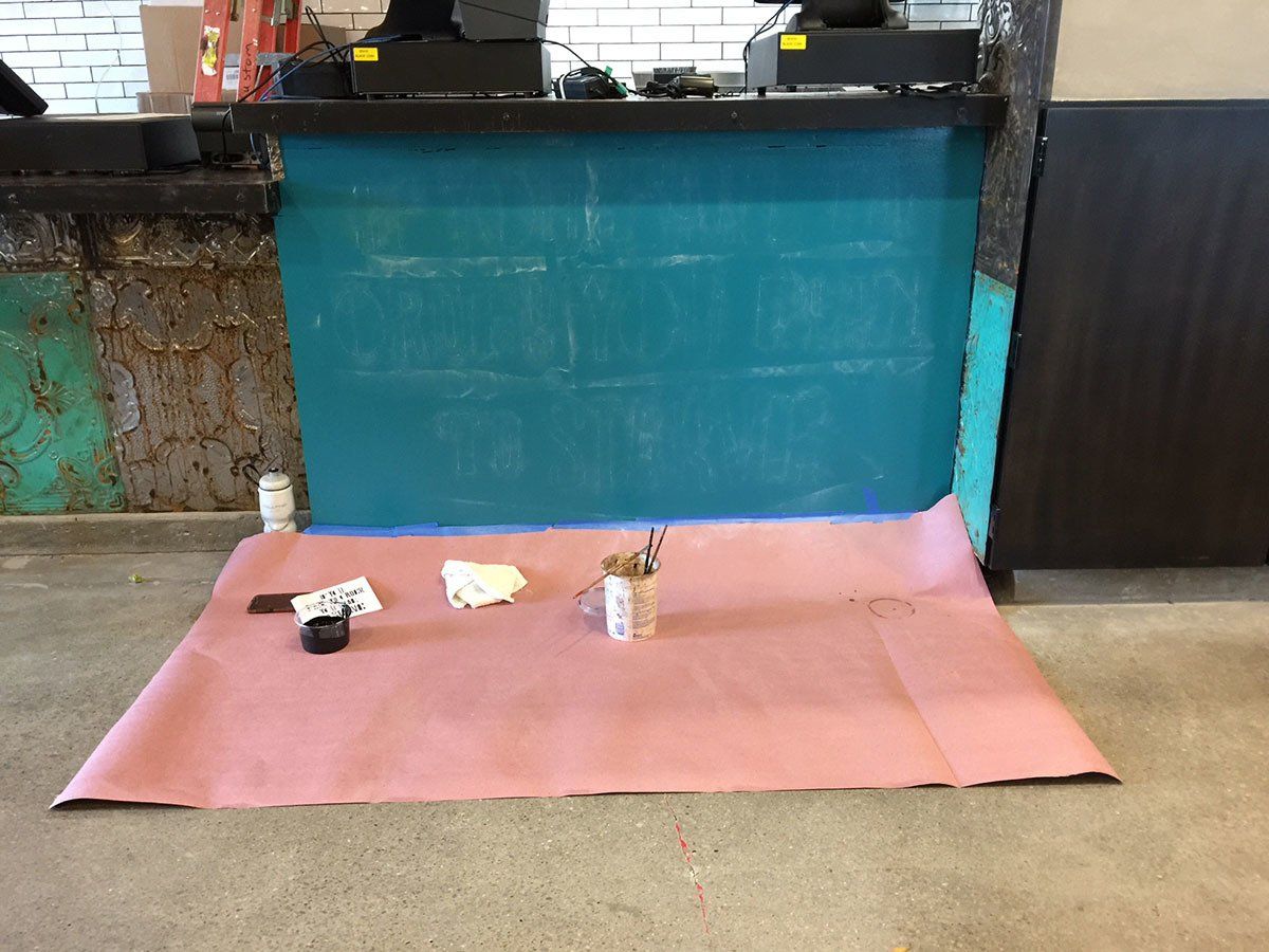 A pink mat is on the floor in front of a blue wall