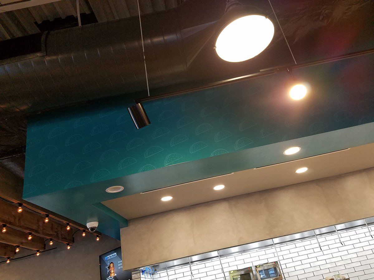 A blue ceiling with a light hanging from it