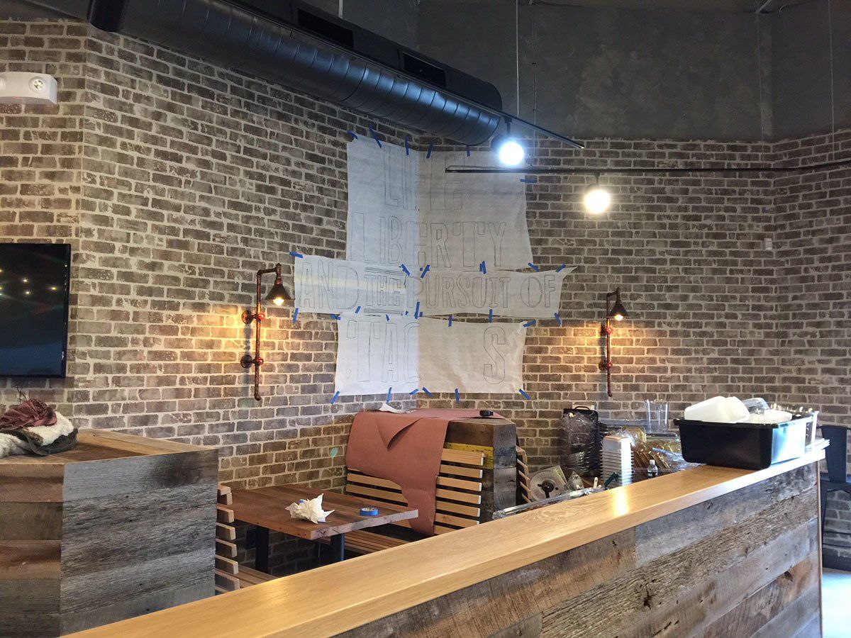 A restaurant with a brick wall and a wooden counter.