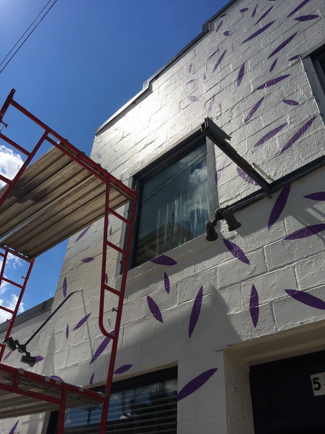 A white building with purple leaves painted on it