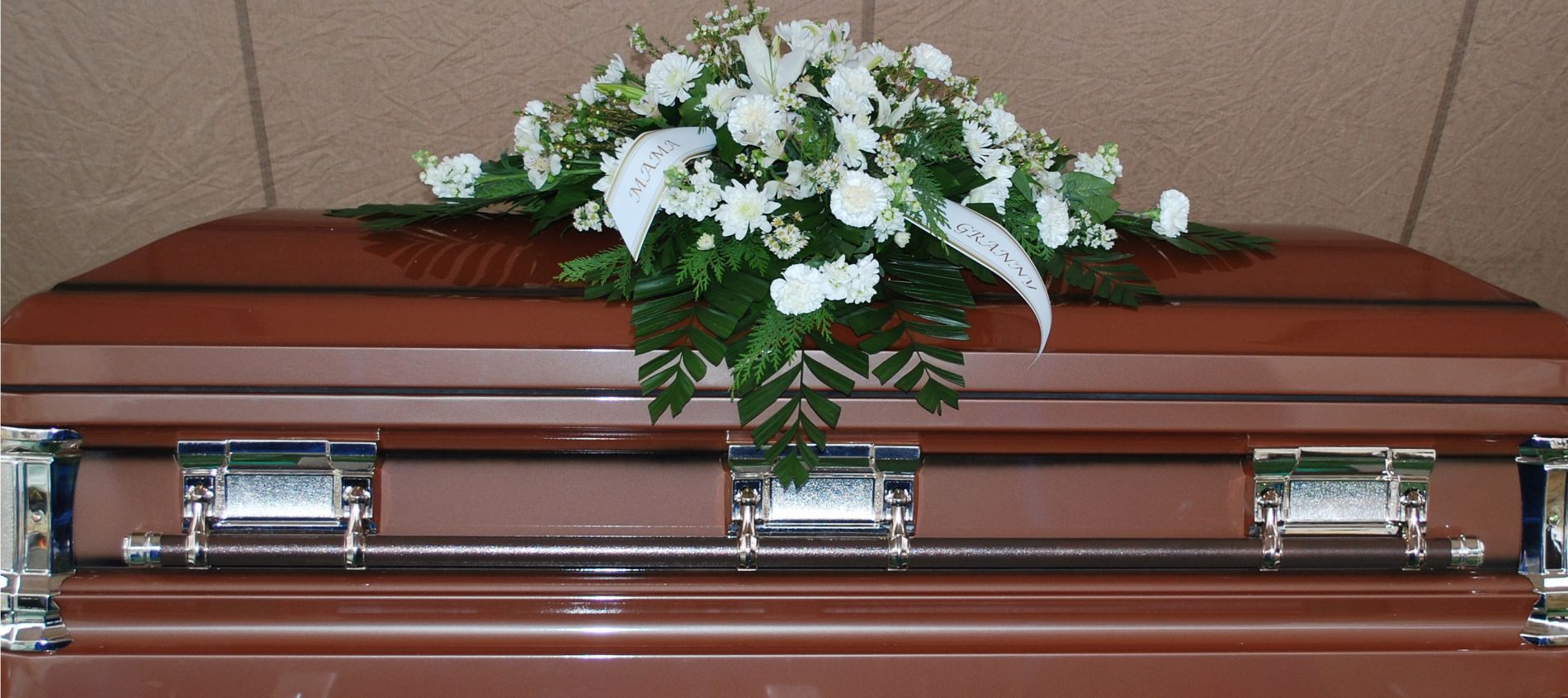 feretro in legno con copribara di fiori bianchi