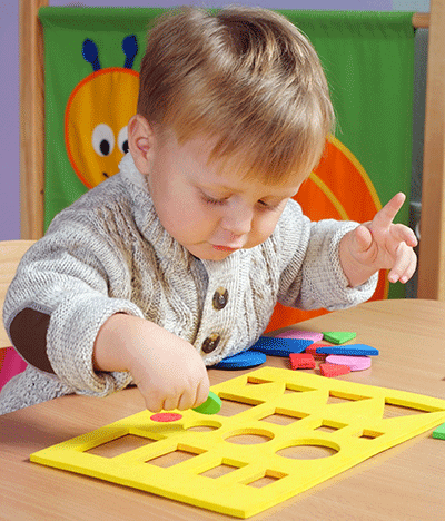 a toddler playing with shapes and colors