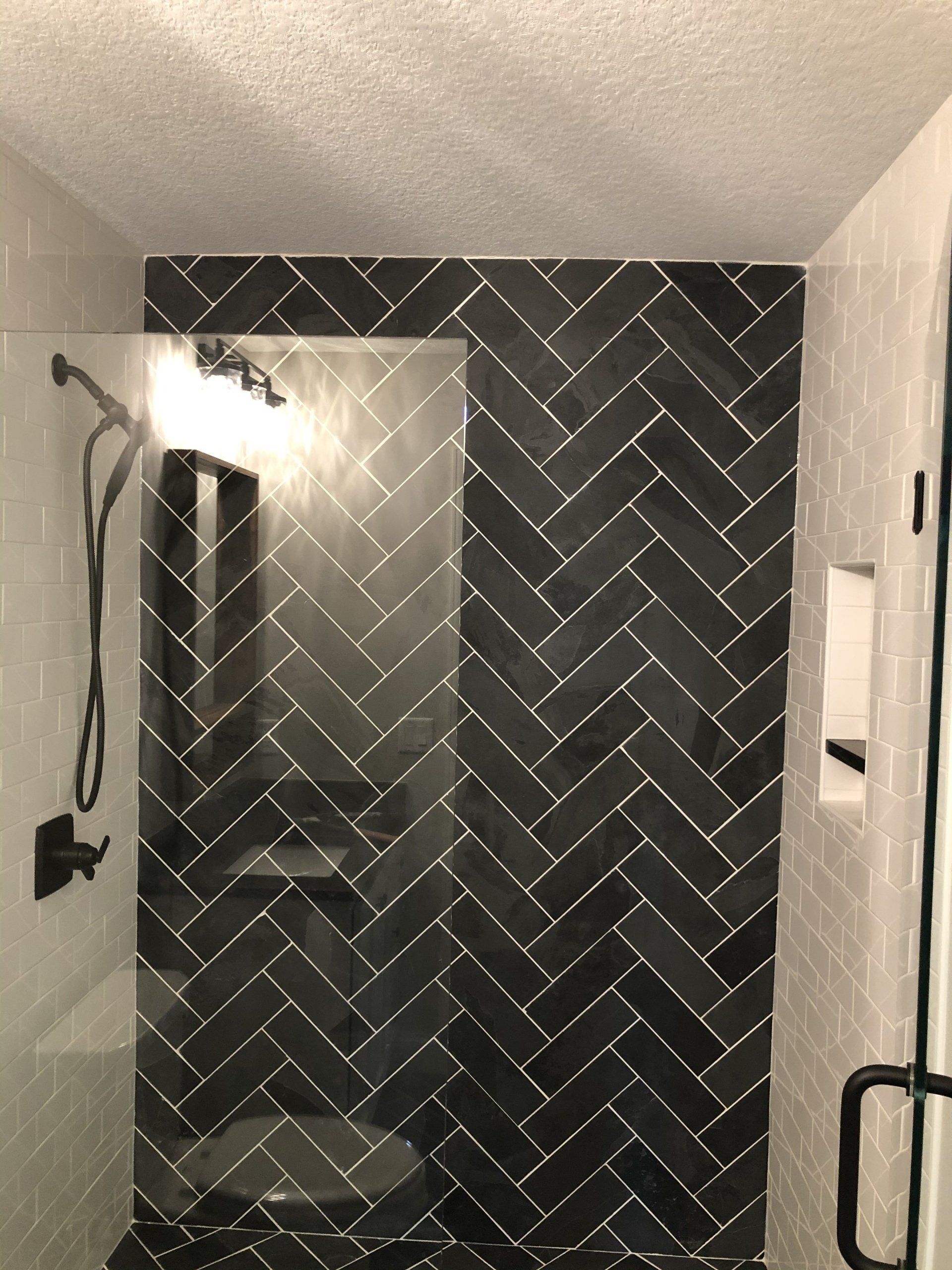 Elderly bathroom remodel | A bathroom with black and white tiles and a walk in shower.