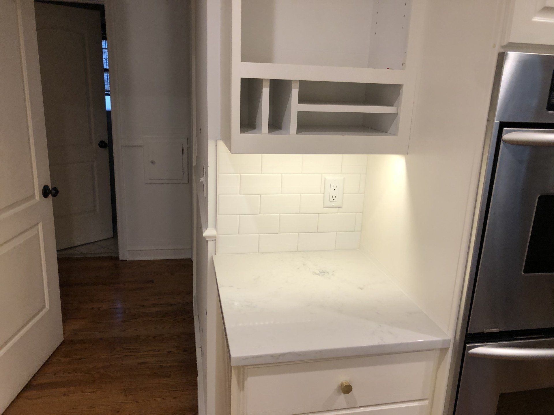 A kitchen with white cabinets and a stainless steel oven.