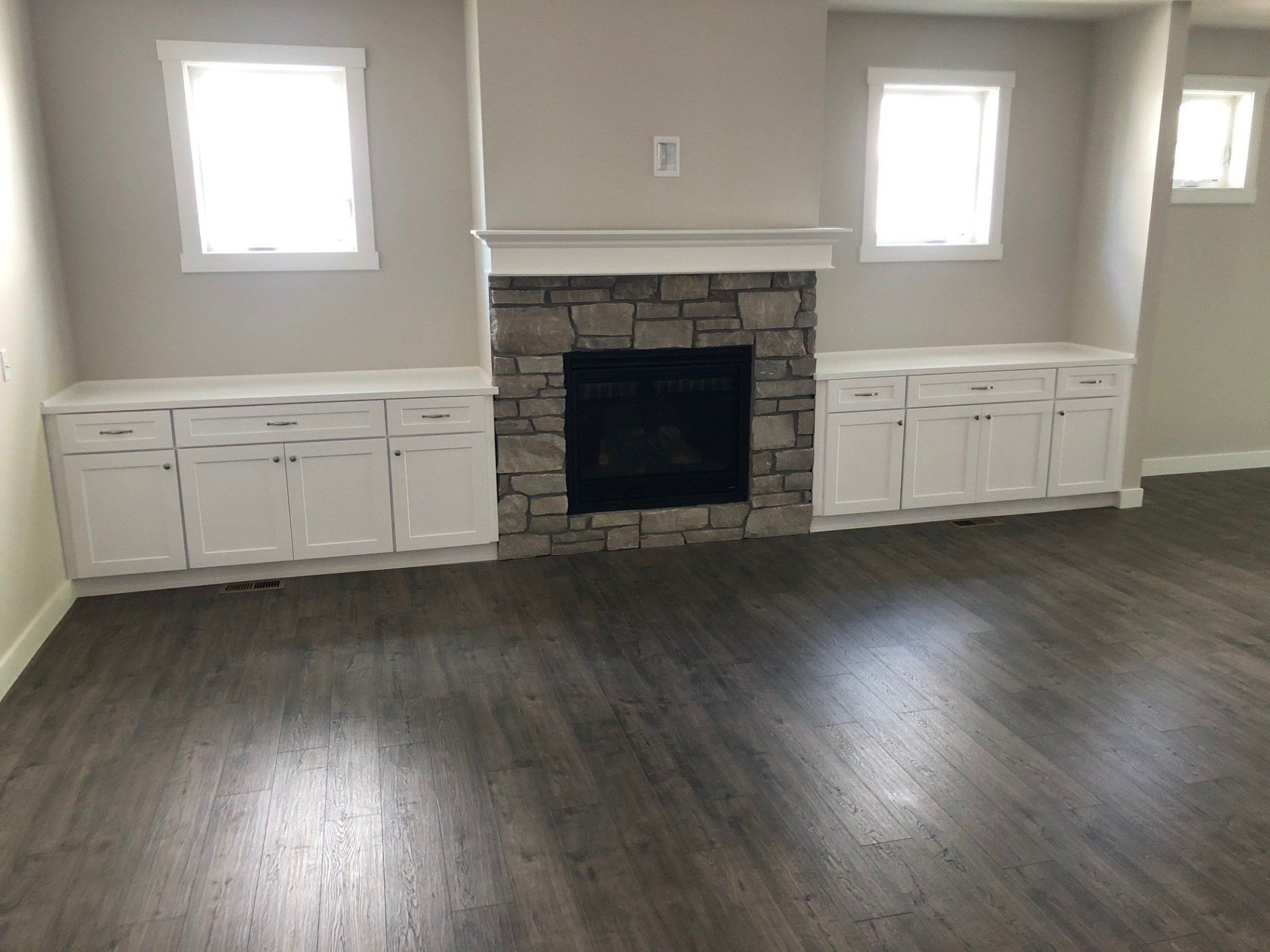 New floor installation | there is a fireplace in the middle of the room.