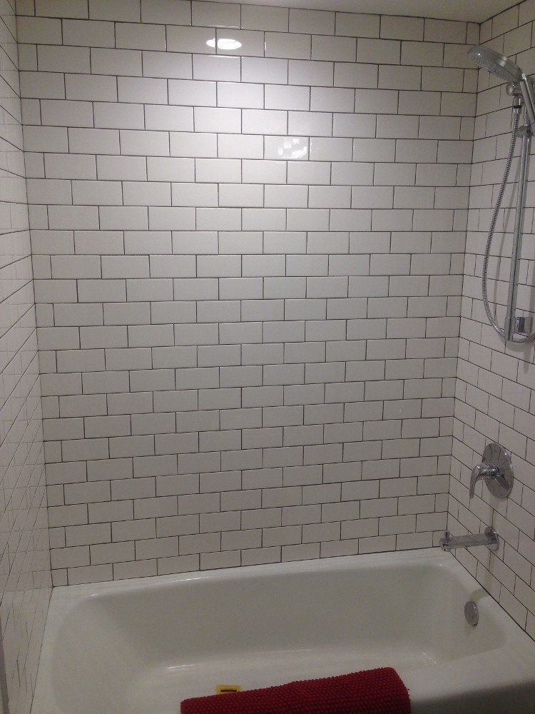 A bathroom with white brick walls and a bathtub
