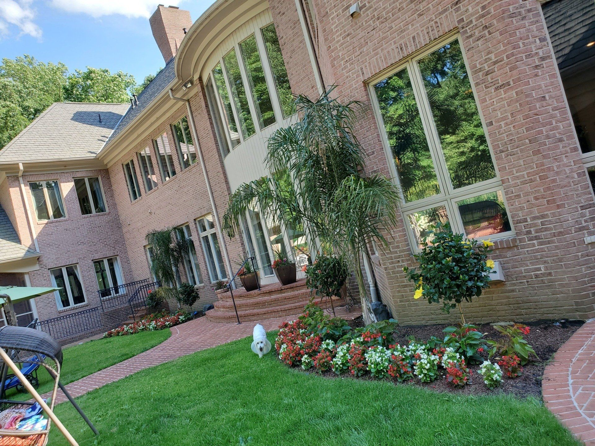 A large brick house with a lush green lawn in front of it.