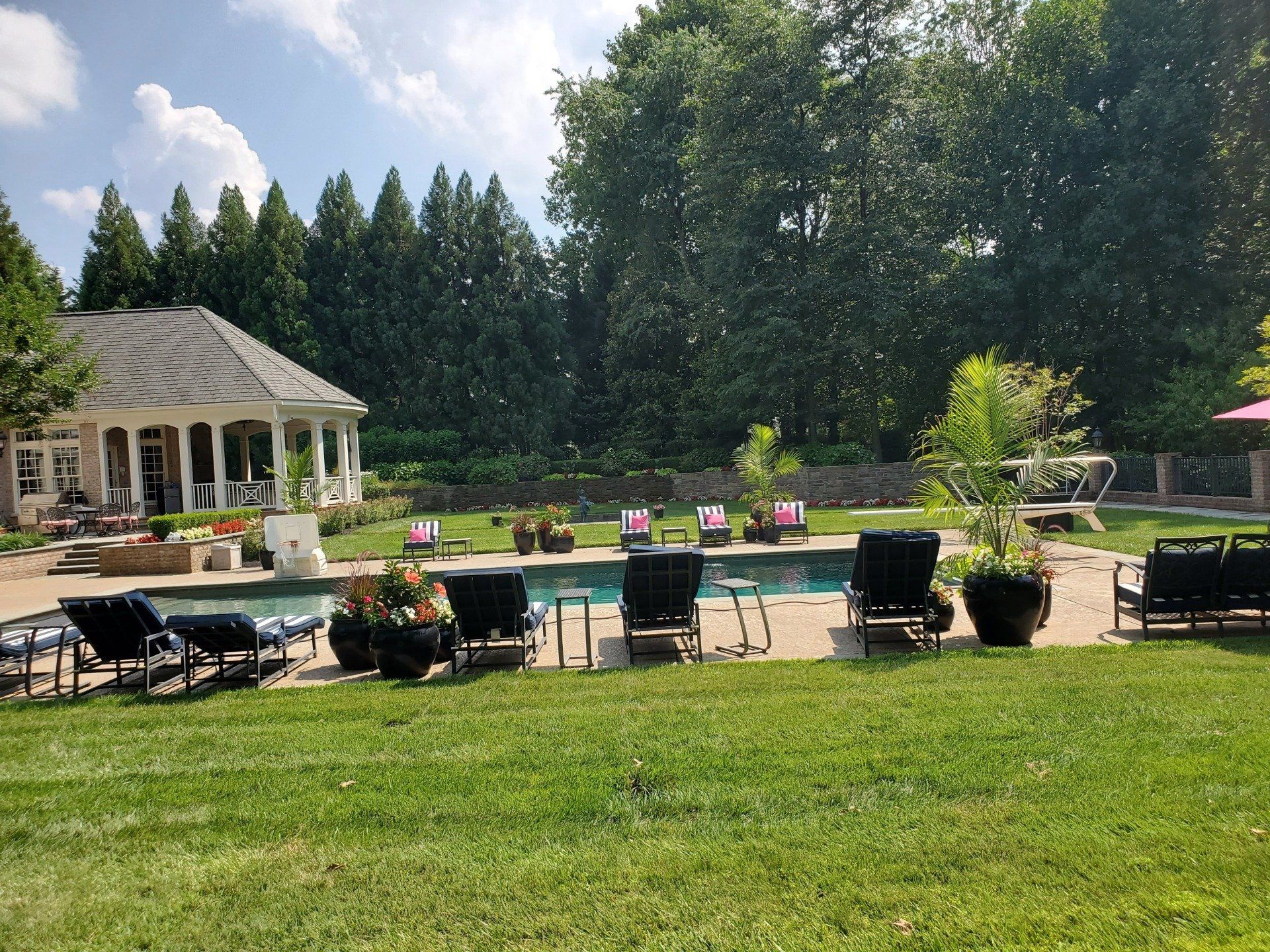 A large backyard with a swimming pool and lawn chairs