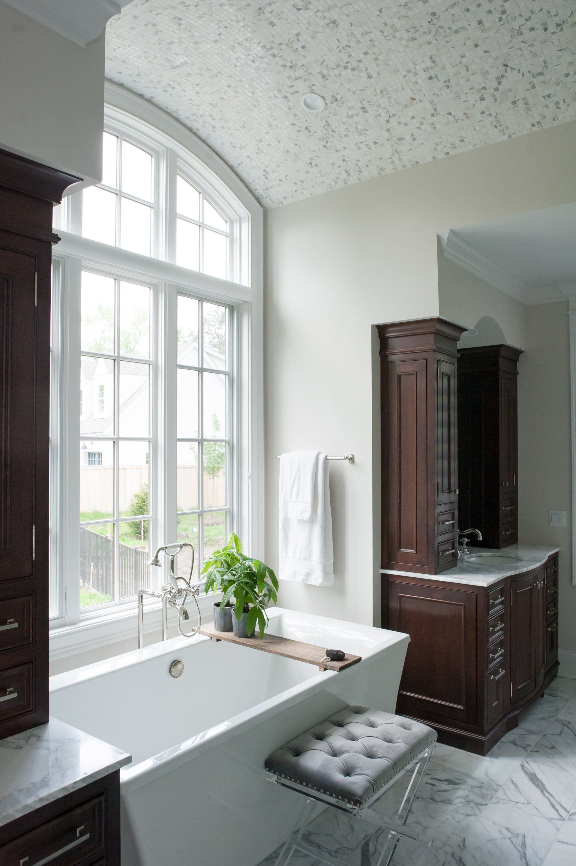 A bathroom with a tub , sink and window