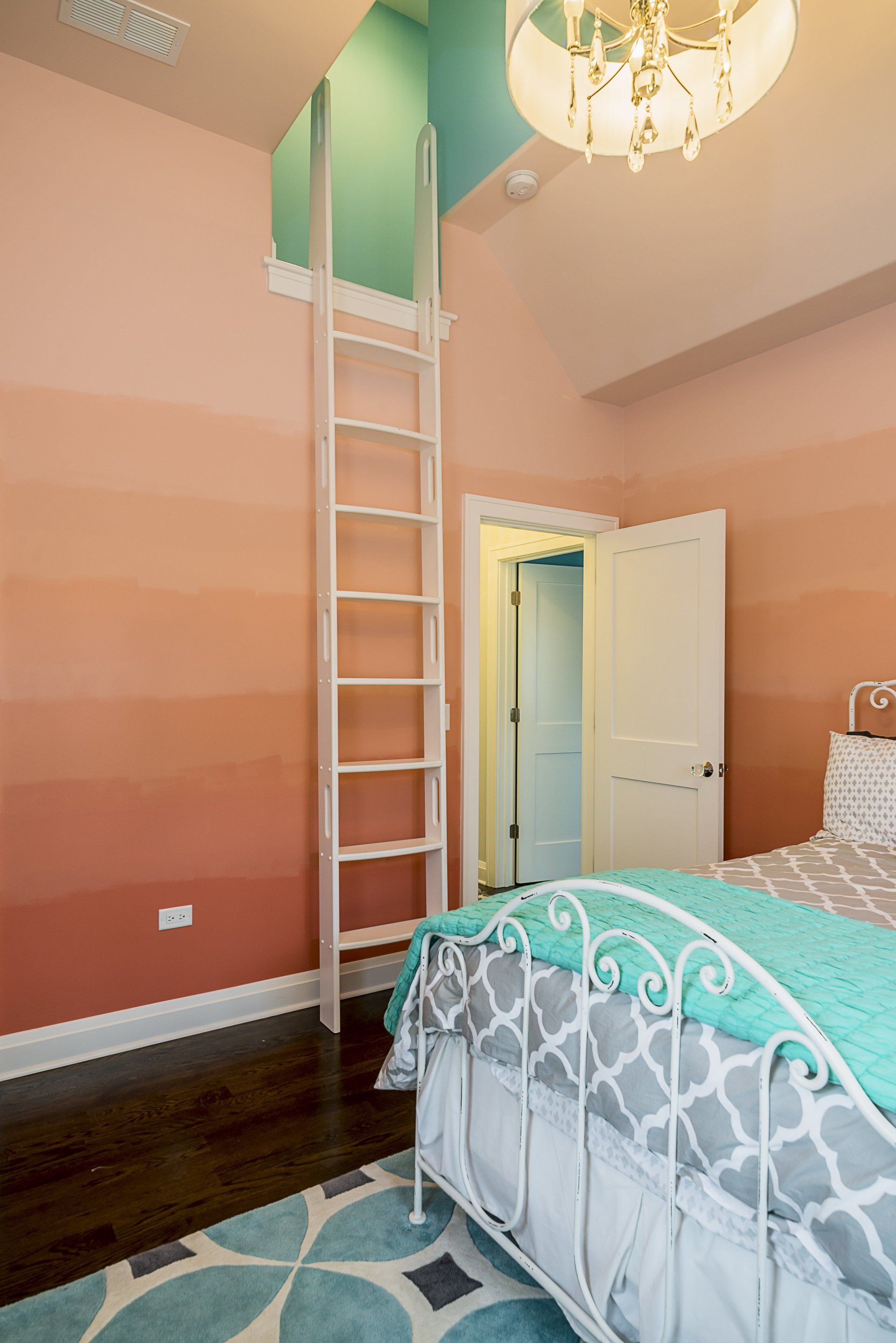 A bedroom with a bed and a ladder leading to a loft.