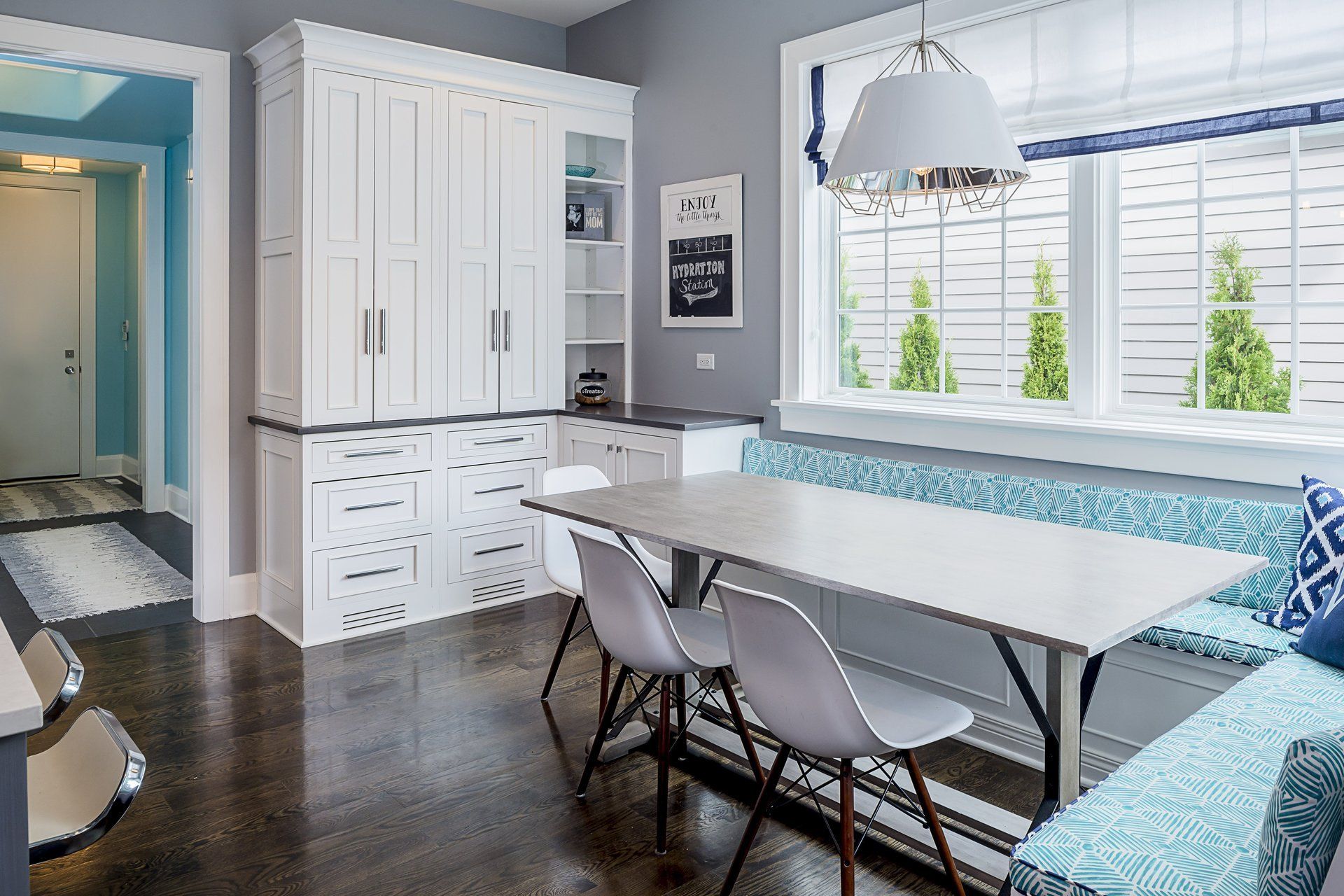 A dining room with a table and chairs and a window seat.