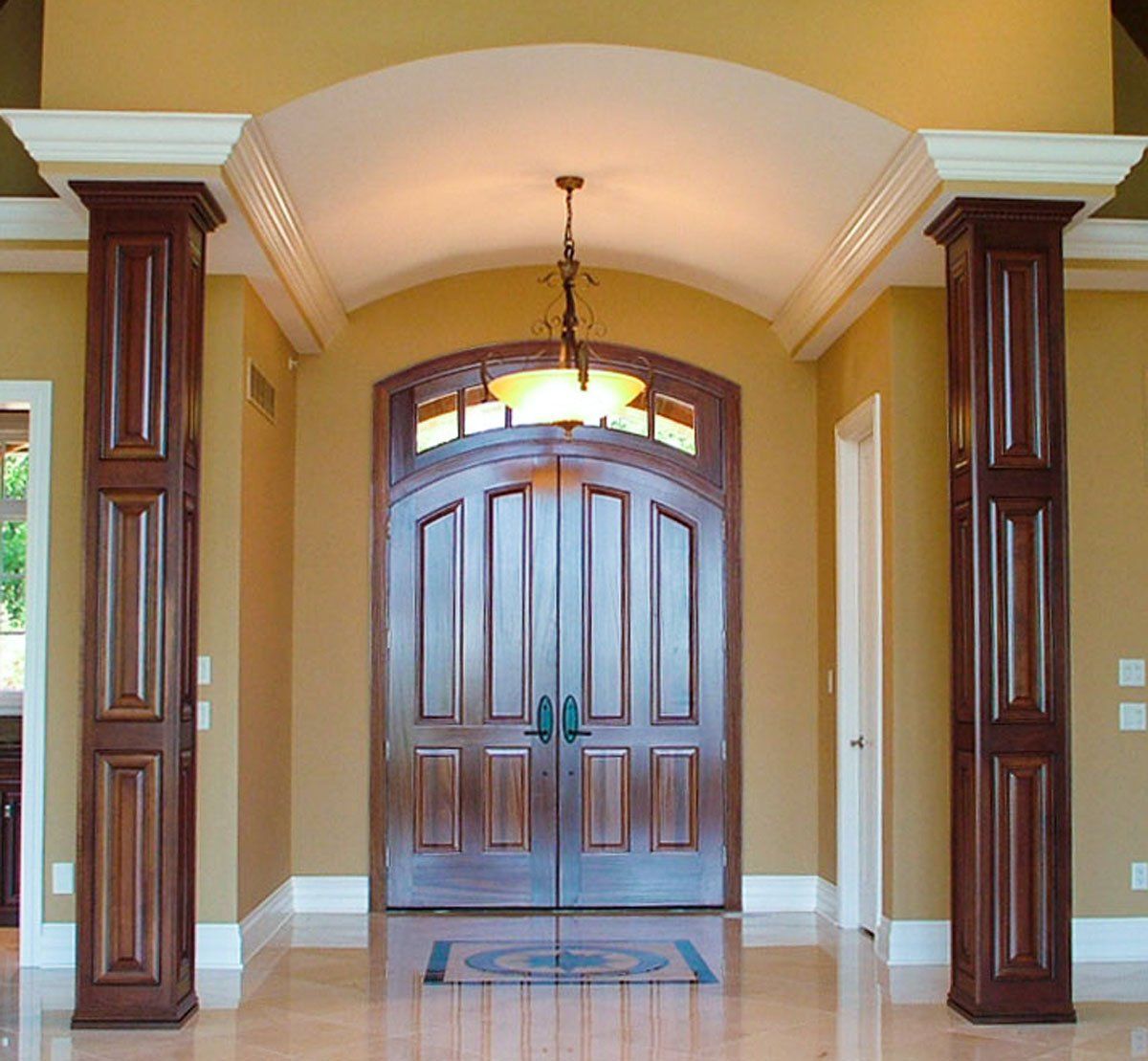 A hallway with columns and a large door