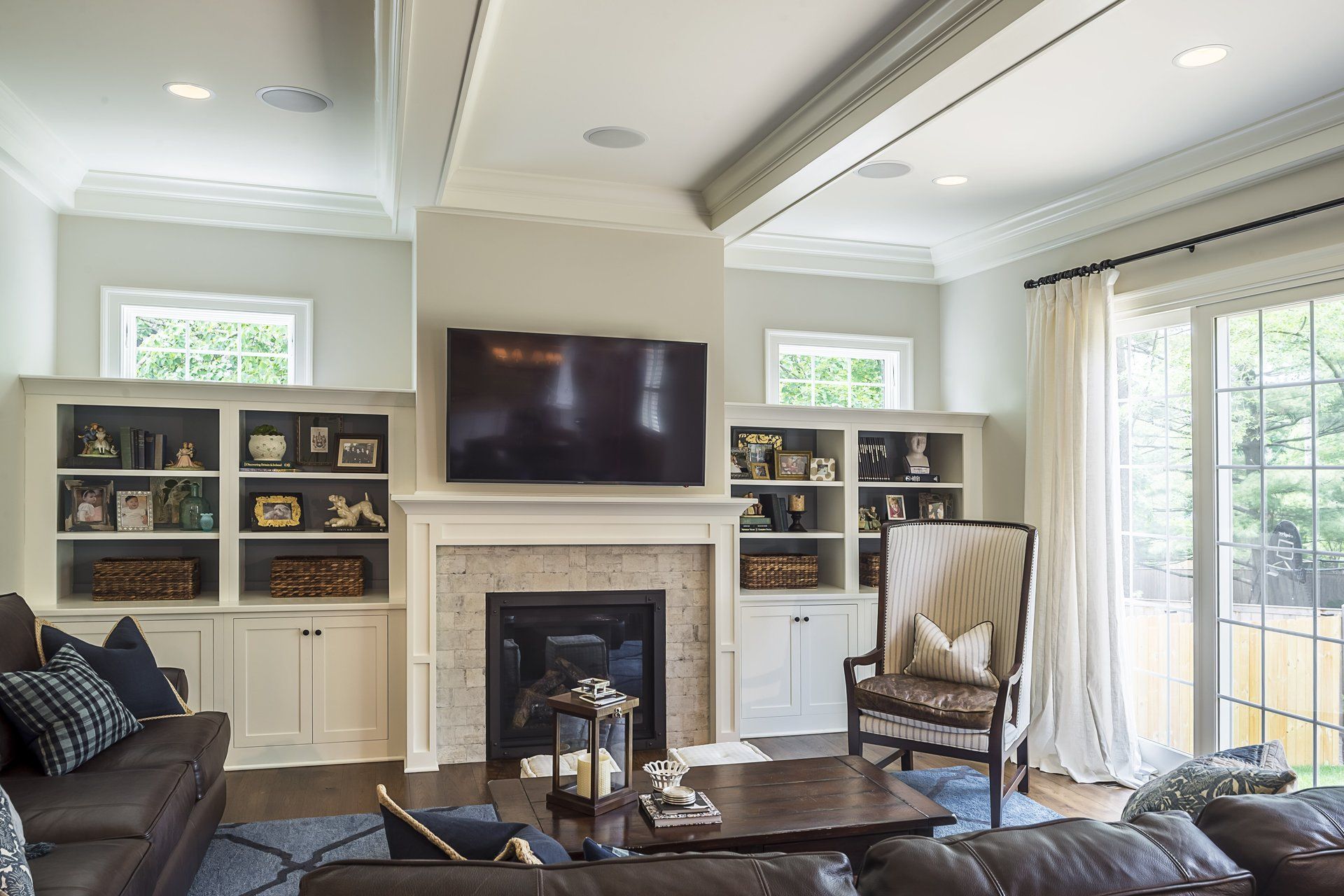 A living room with a fireplace , couch , chair and television.