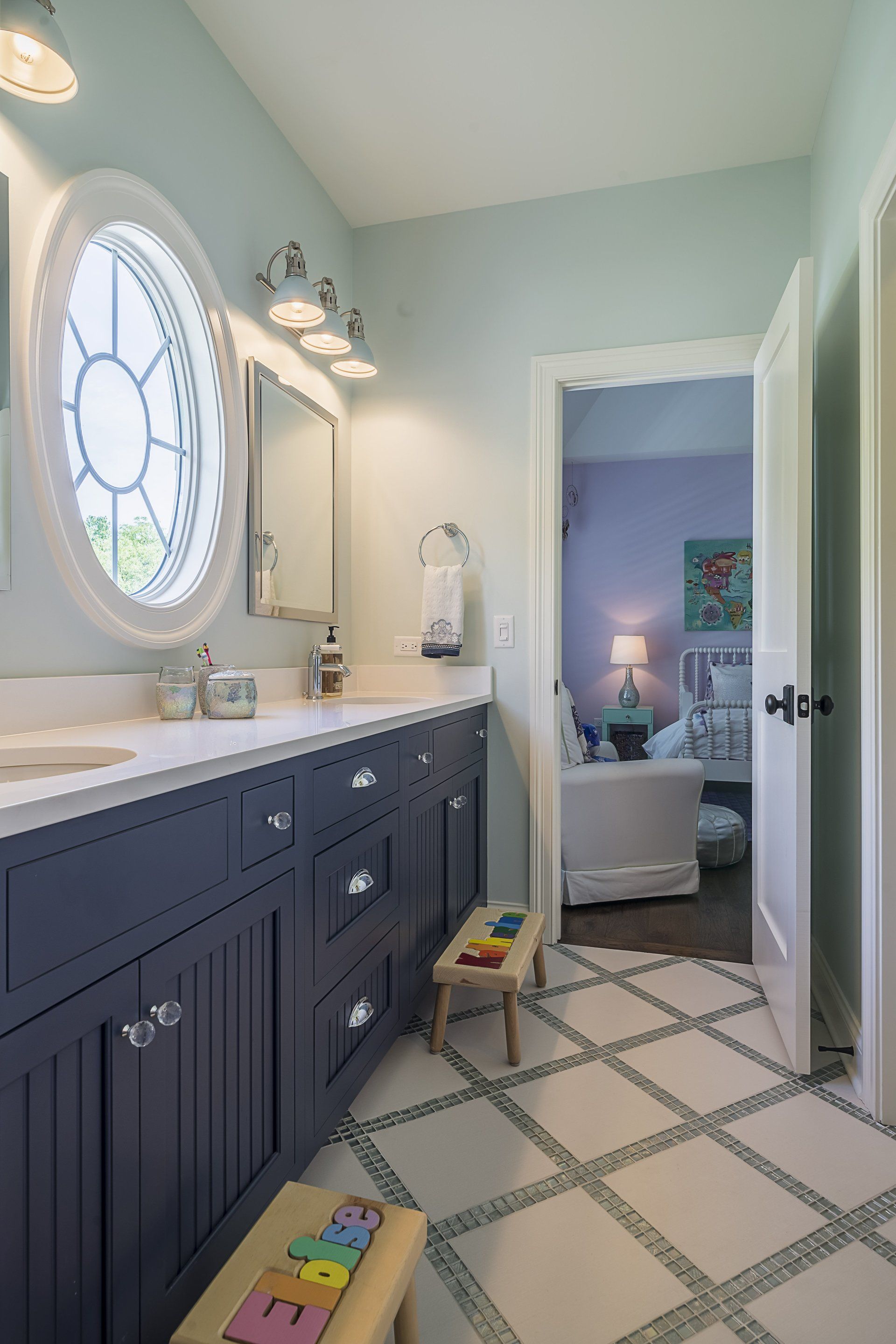 A bathroom with two sinks , a mirror , and a stool.