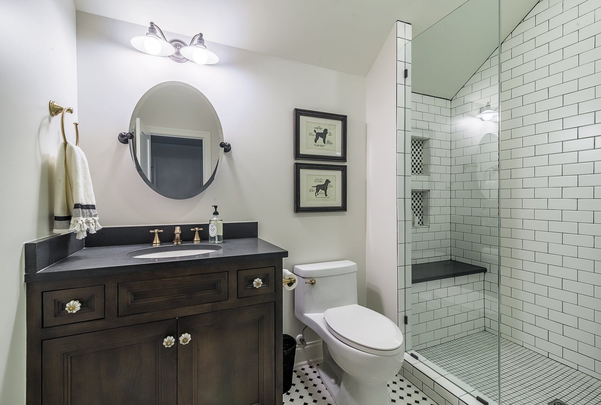 A bathroom with a toilet , sink , mirror and walk in shower.