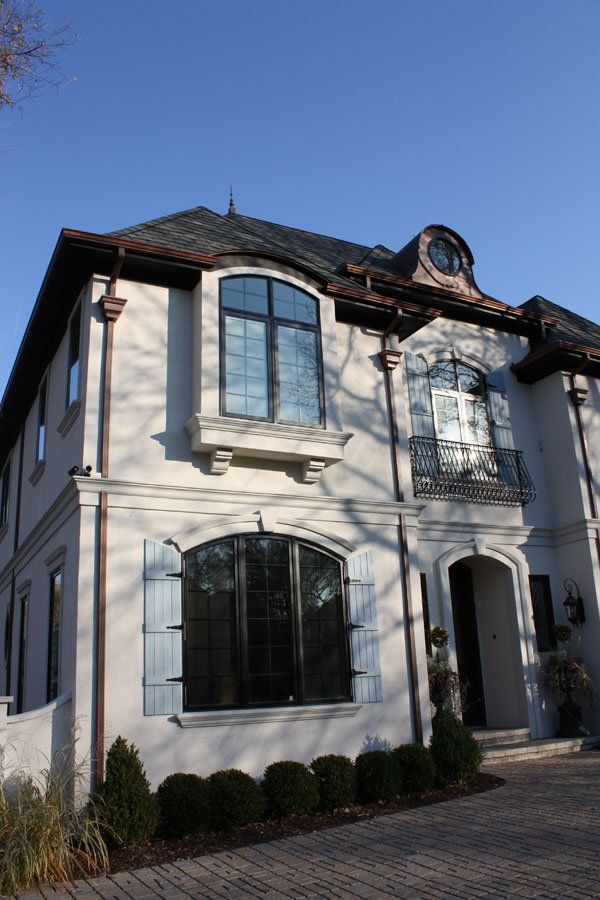 A large white house with blue shutters on the windows