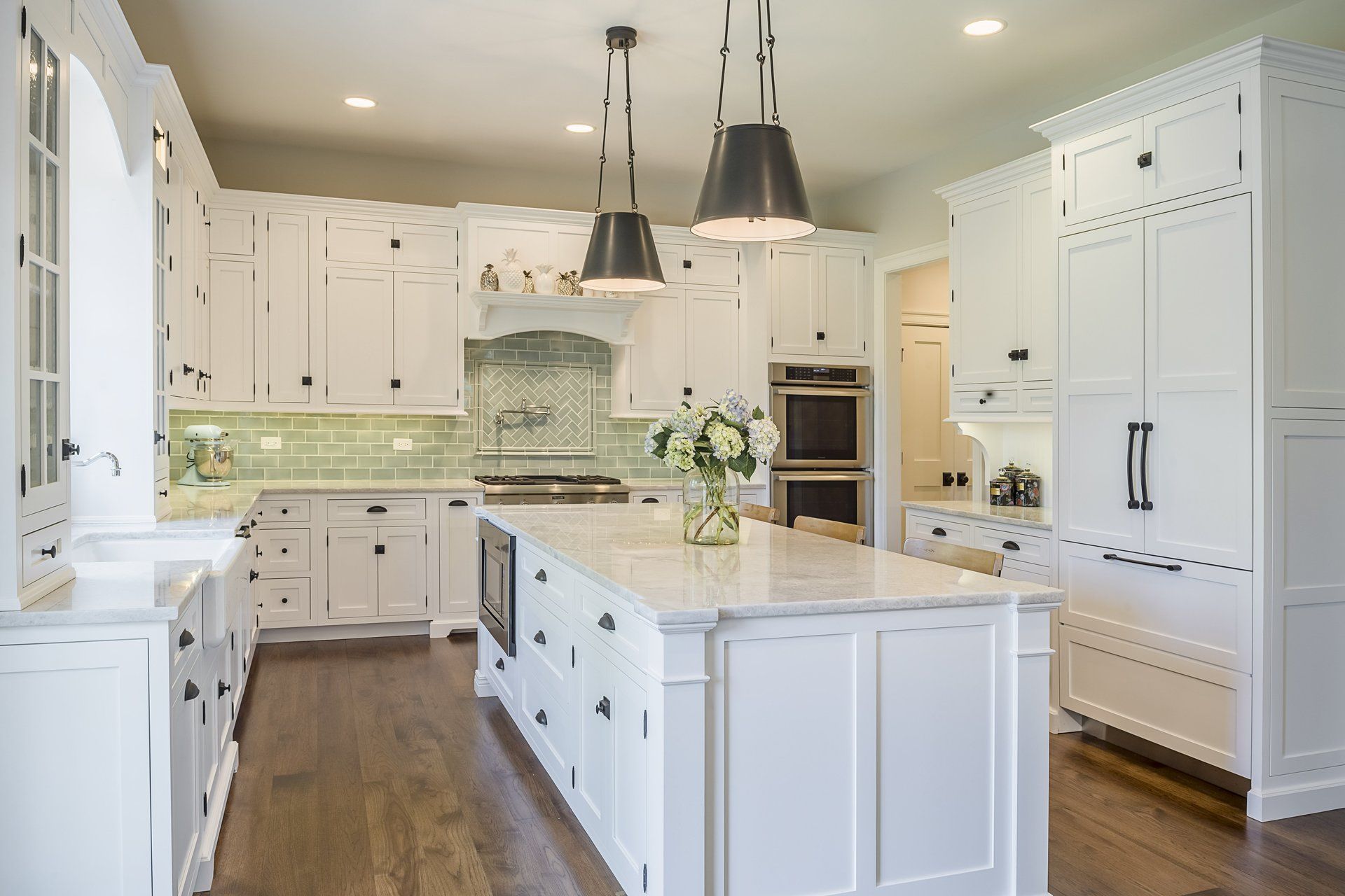 A large kitchen with white cabinets and a large island in the middle.